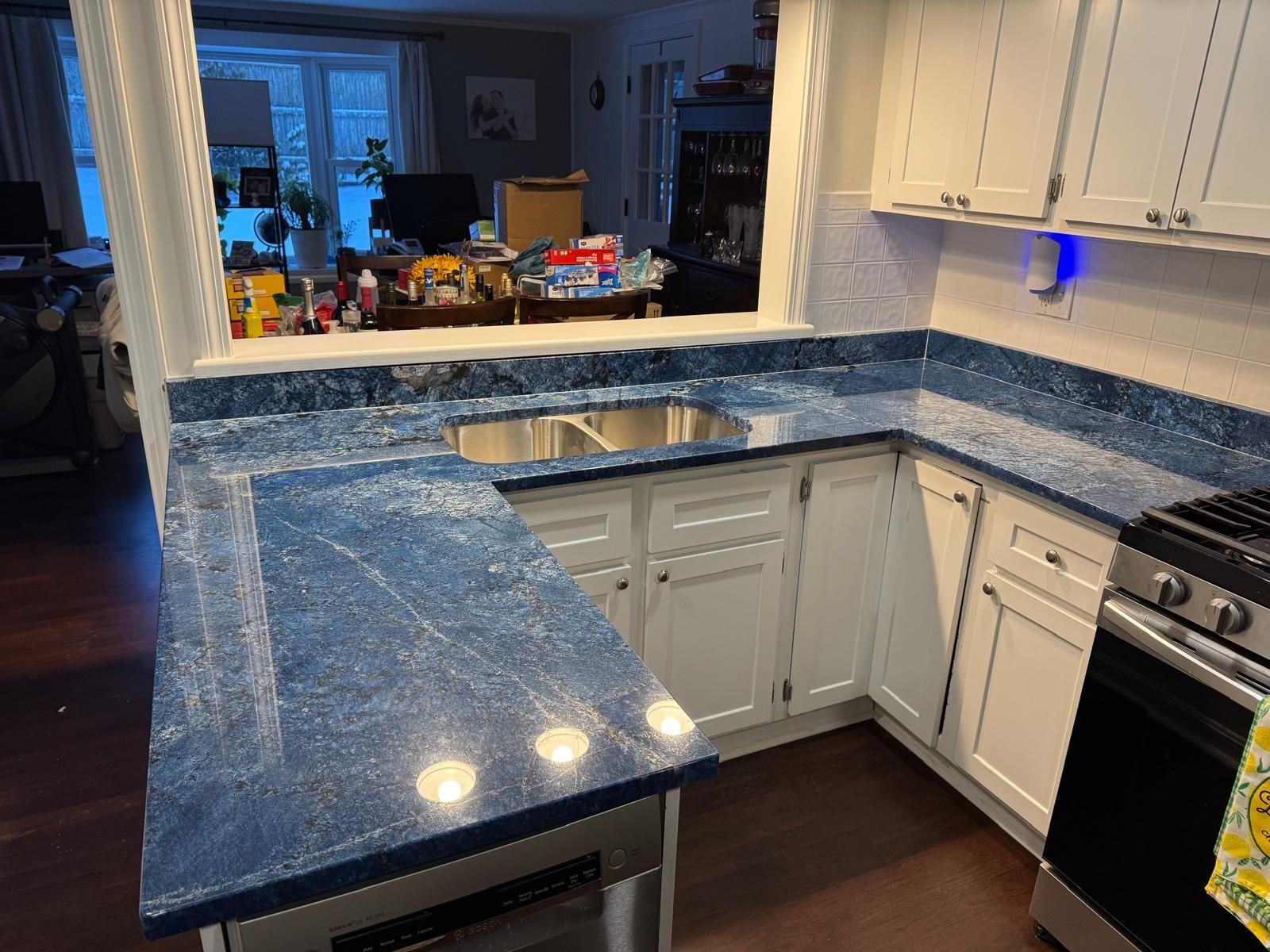 Kitchen with blue countertops, white cabinets, and stainless steel appliances.