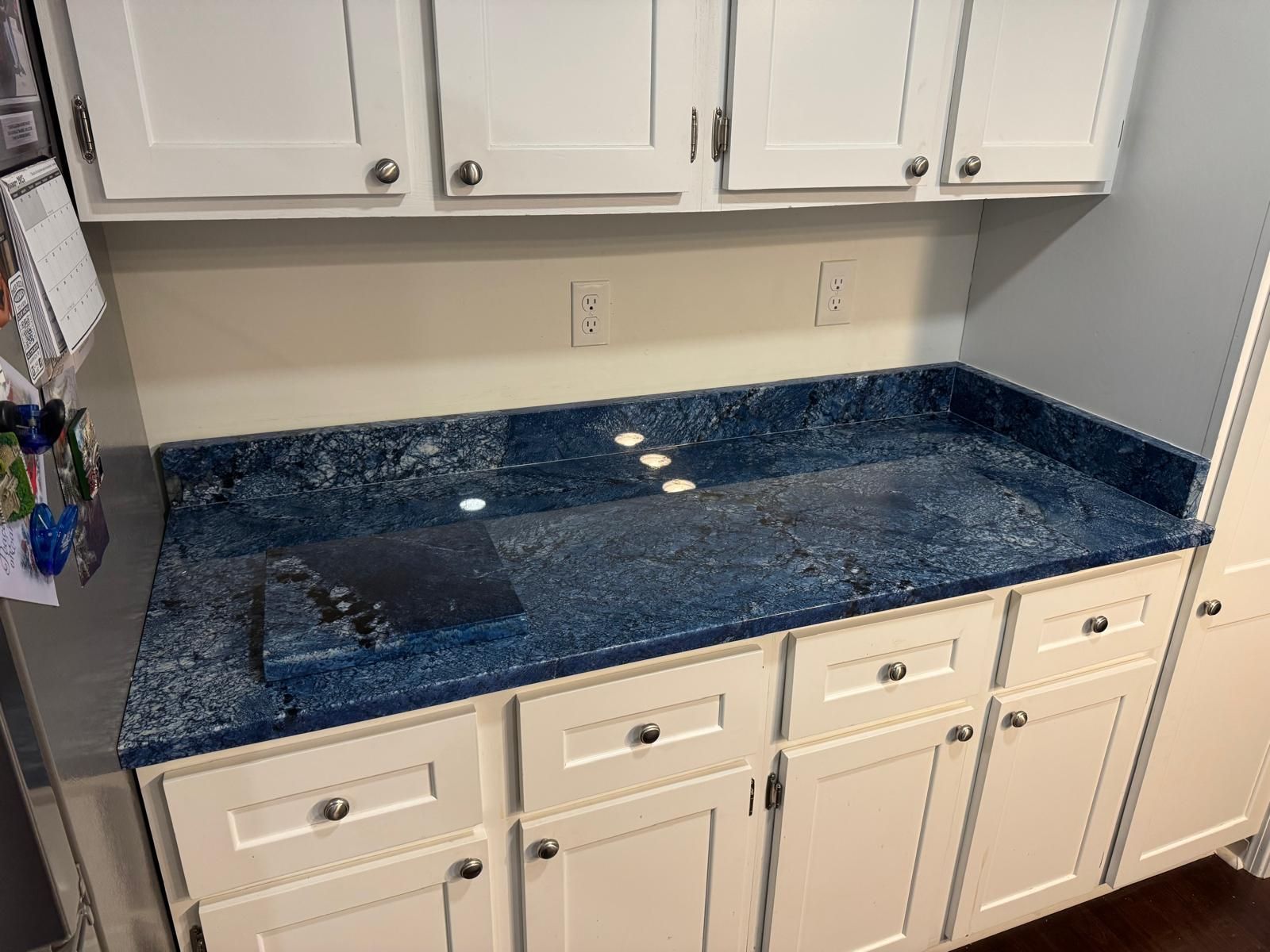 White kitchen cabinets with blue countertop.