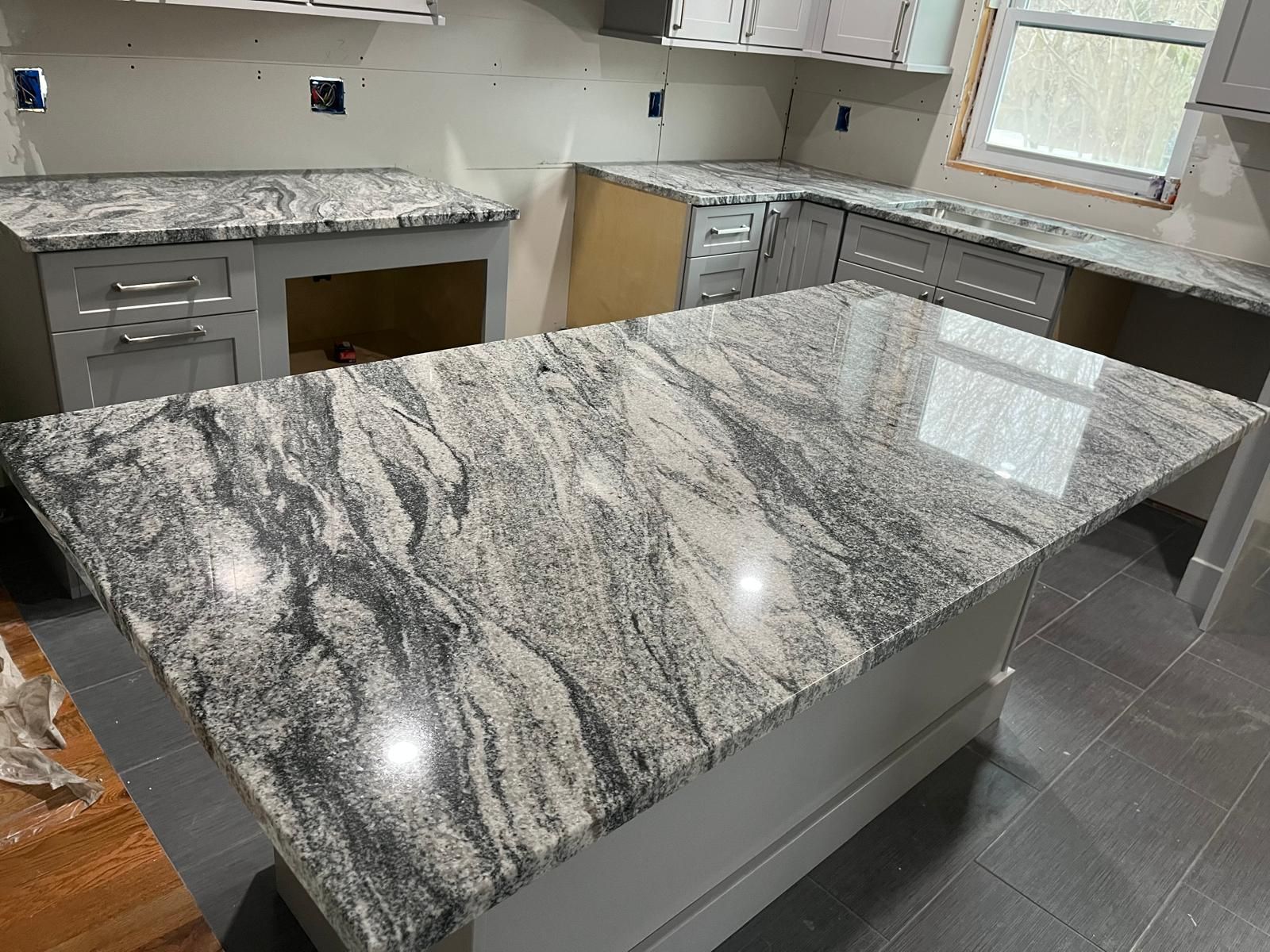 Kitchen with gray cabinets, granite countertops, and an island.