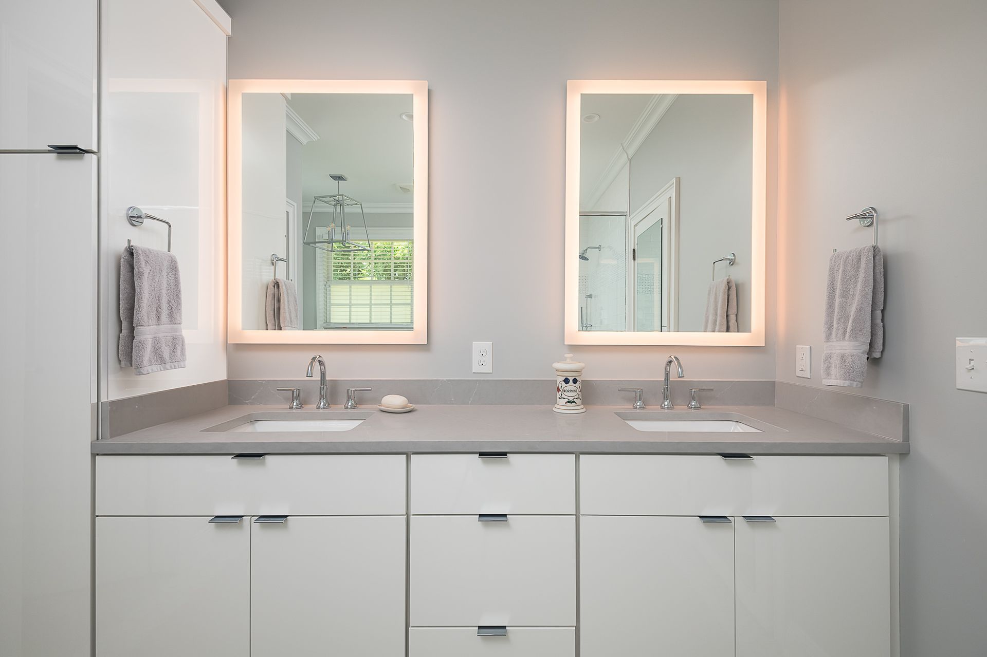A bathroom with two sinks and two mirrors.