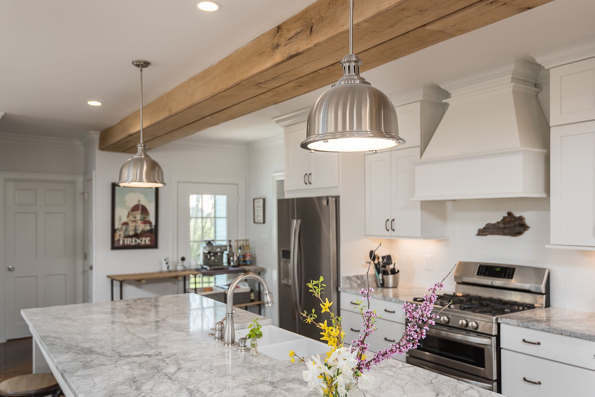 A kitchen with white cabinets , granite counter tops , stainless steel appliances and a large island.