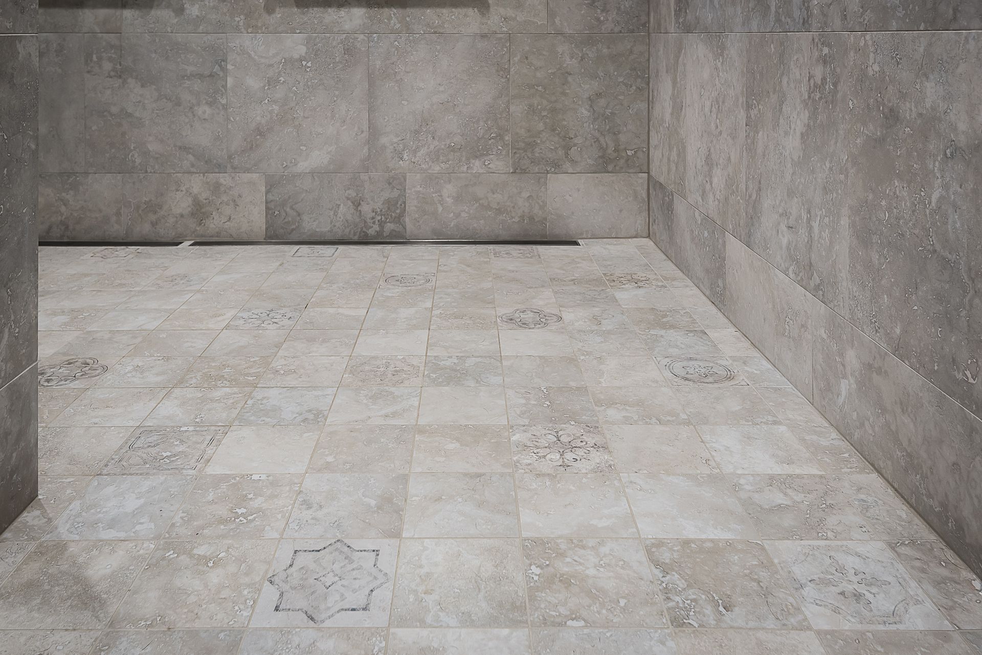 A corner of a room with a tiled floor and concrete walls.
