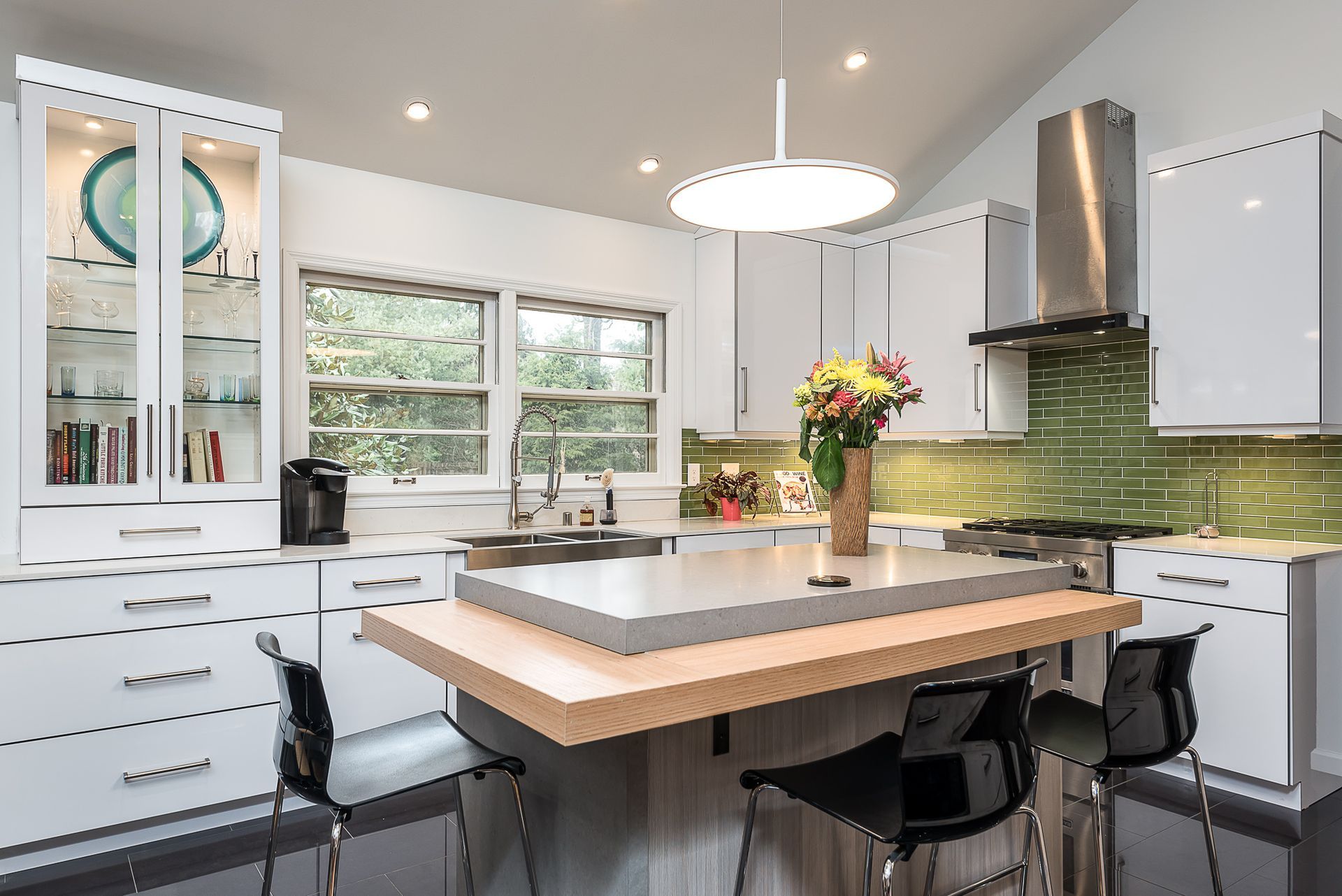 A kitchen with white cabinets and a large island in the middle.