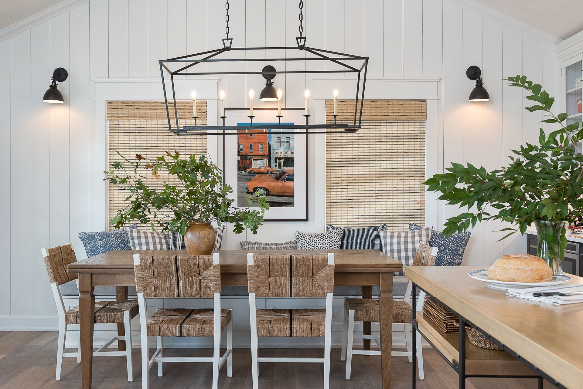 A dining room with a table and chairs and a chandelier hanging from the ceiling.
