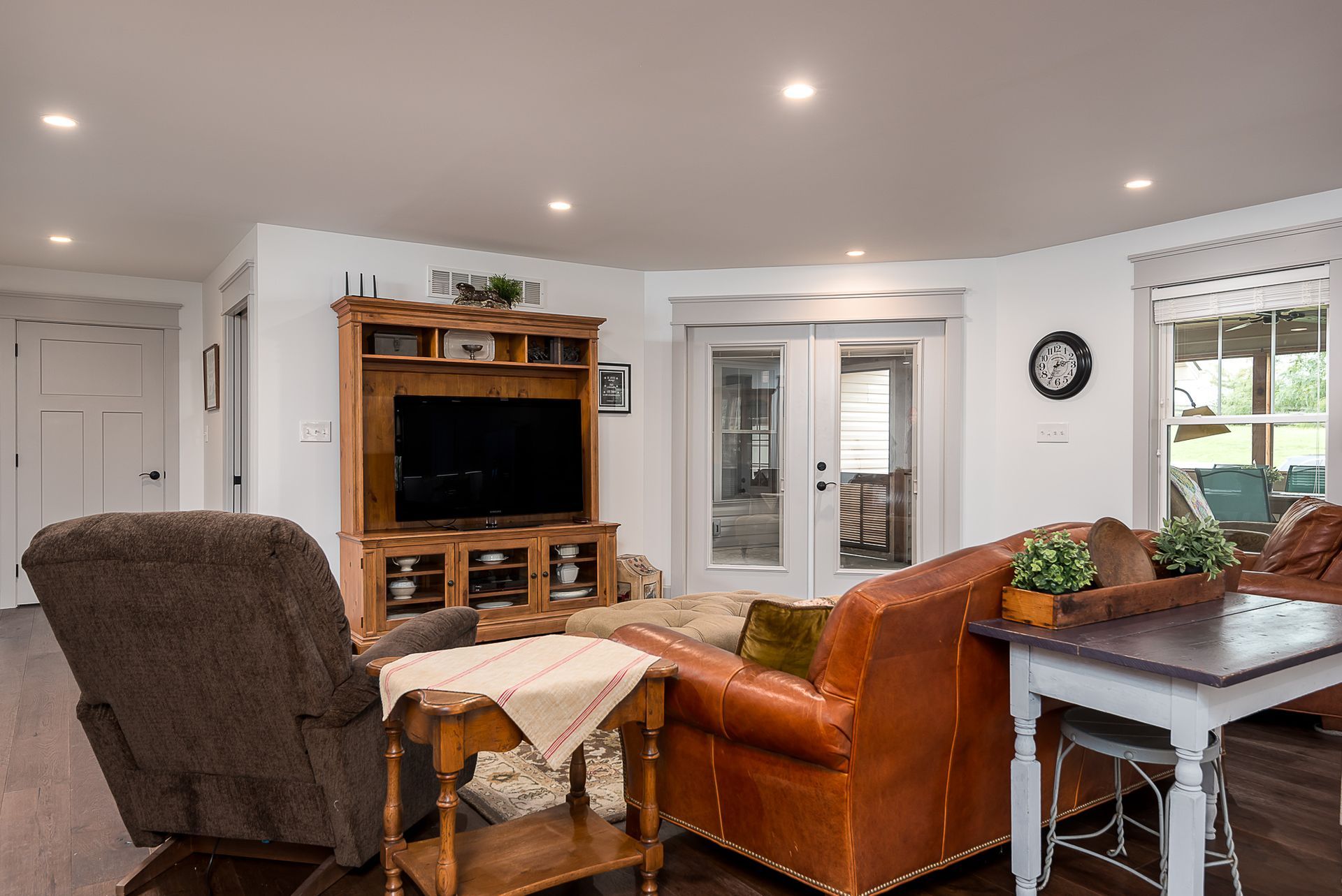 A living room with a couch , chair , table and television.