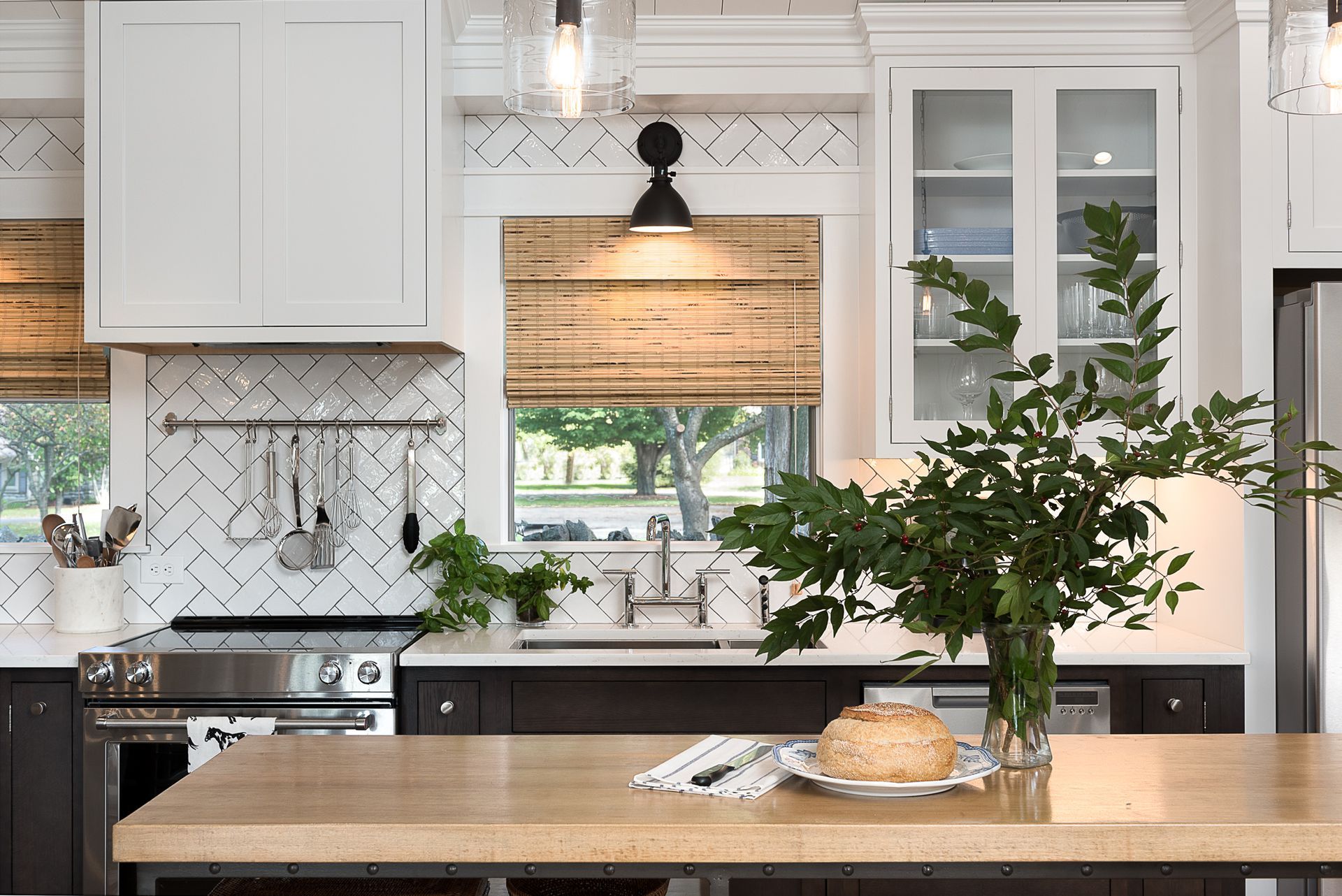 A kitchen with a large island , a sink , a stove , and a window.