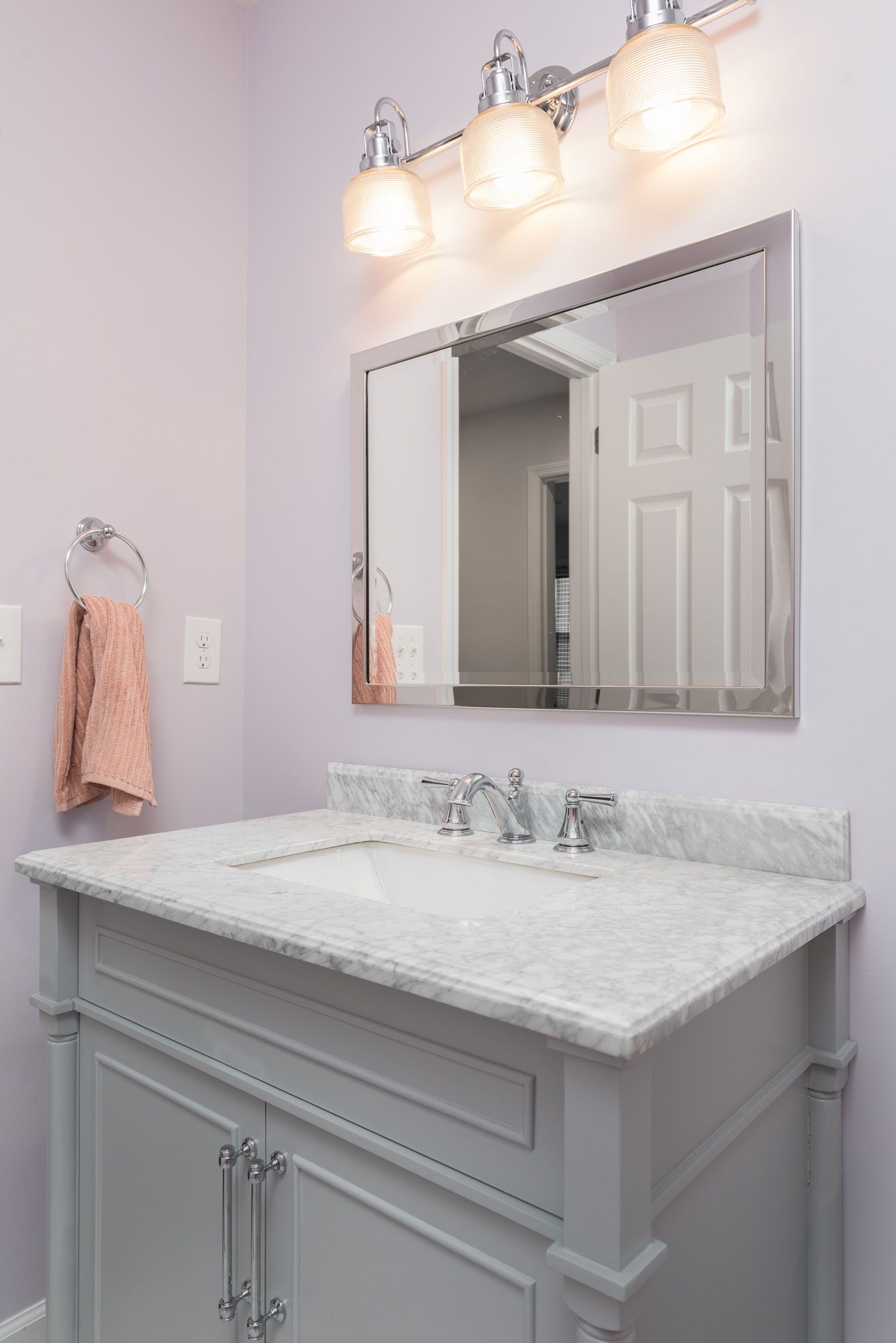 A bathroom with a sink , mirror and light fixtures.
