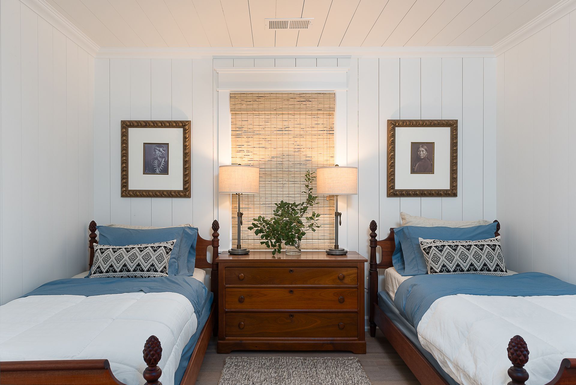 A bedroom with two twin beds and a dresser.