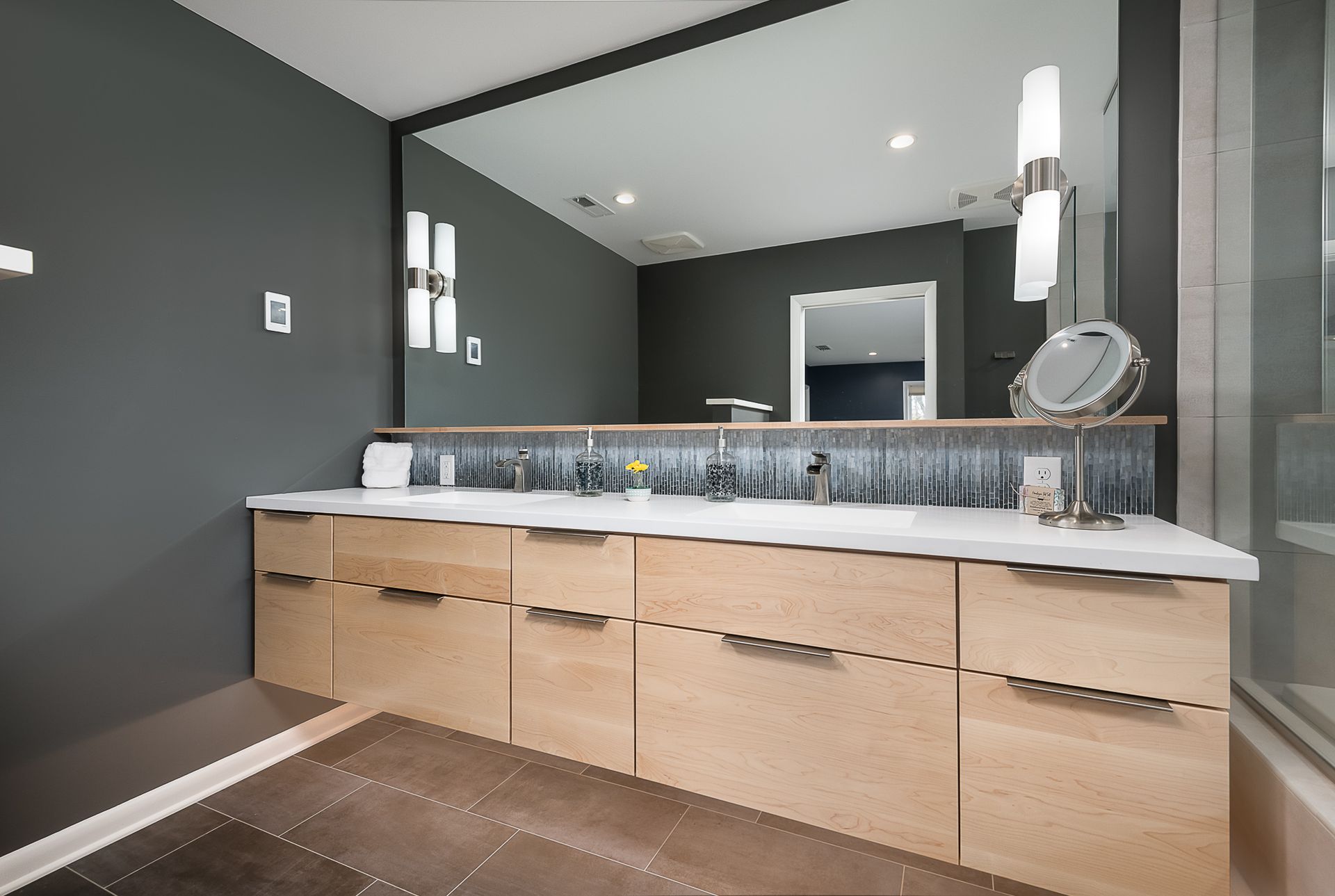 A bathroom with two sinks and a large mirror