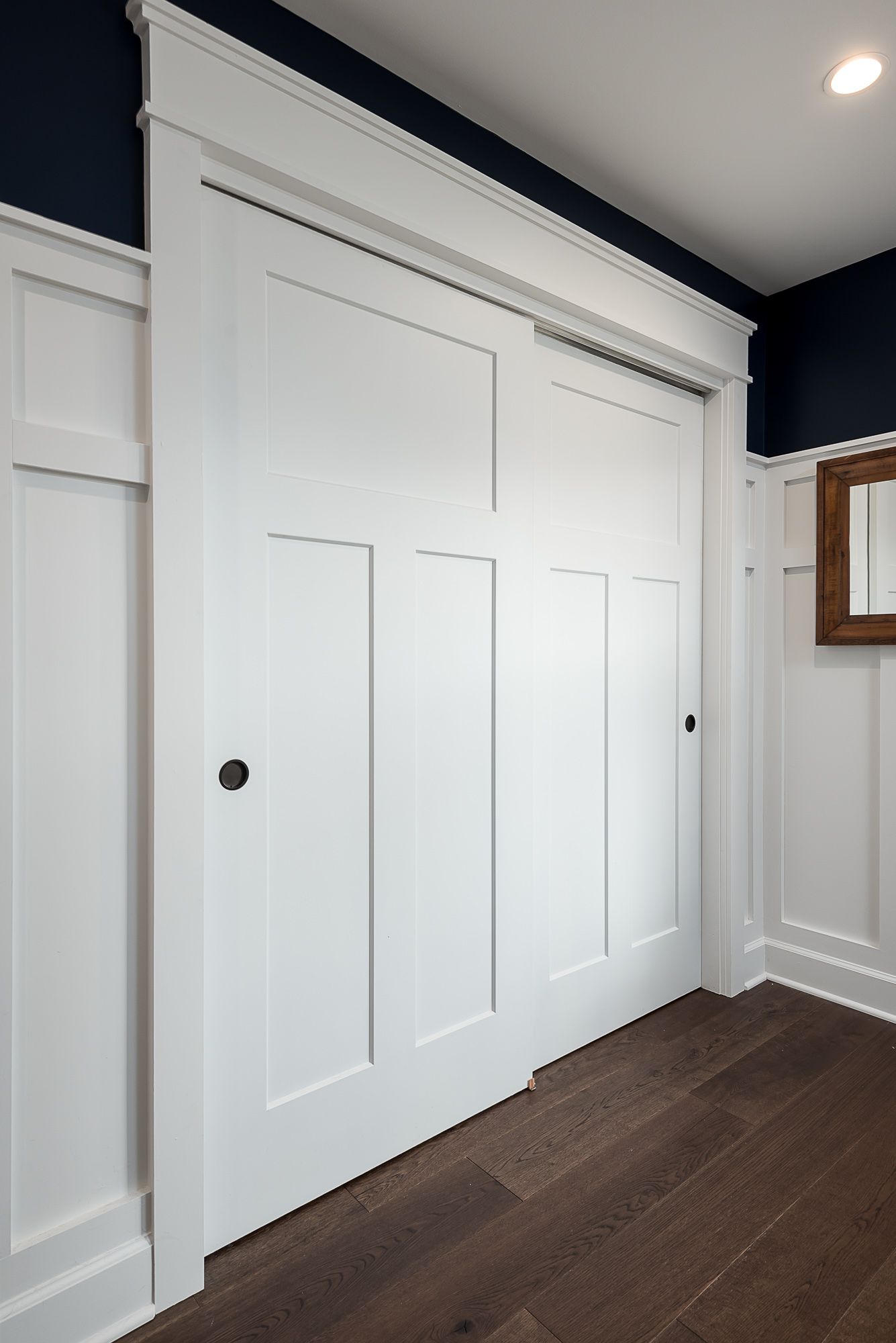 A closet with sliding doors and a mirror on the wall.