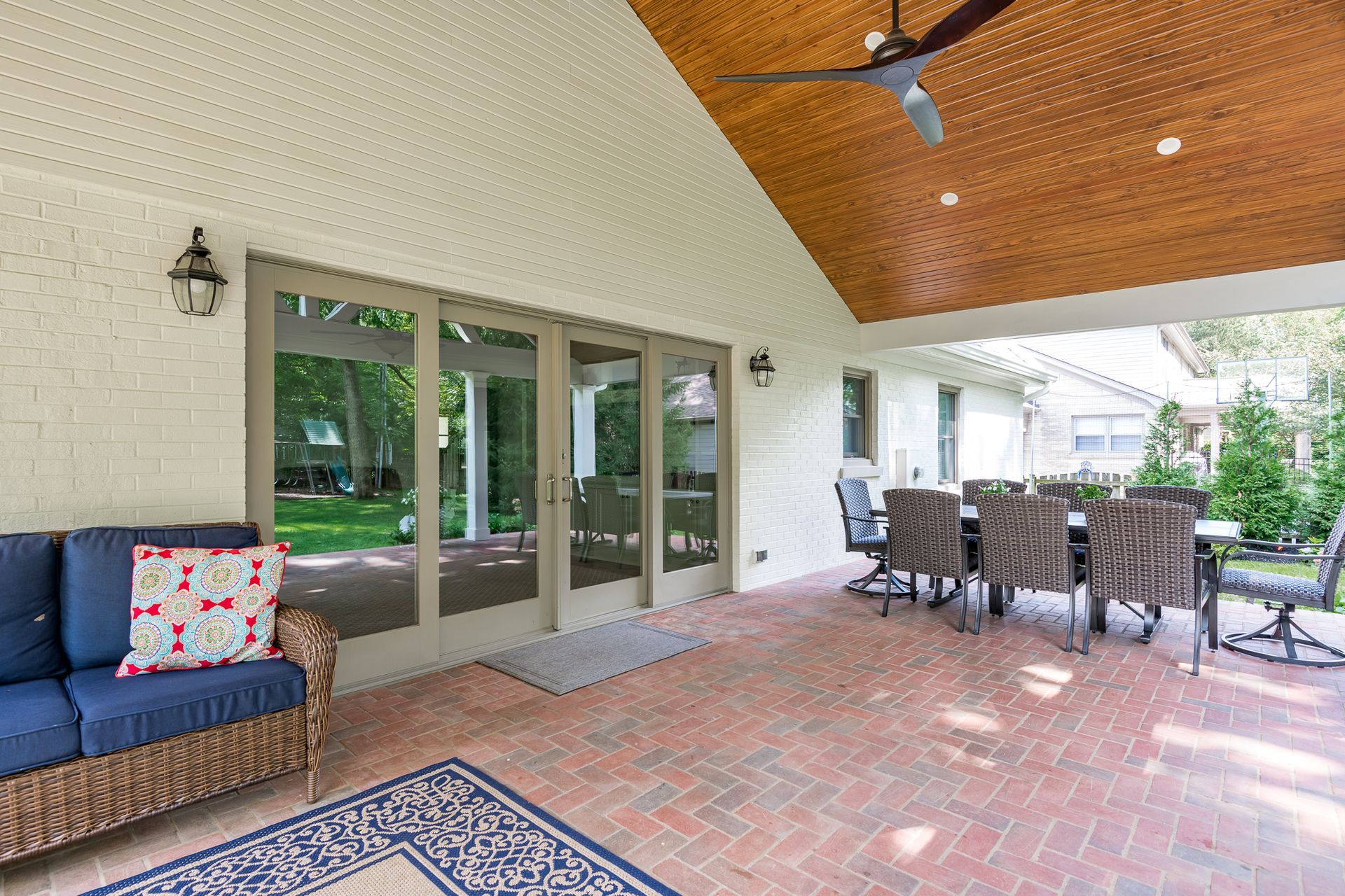 A patio with a table and chairs and a ceiling fan