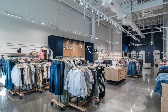 A clothing store with a lot of clothes hanging on racks.