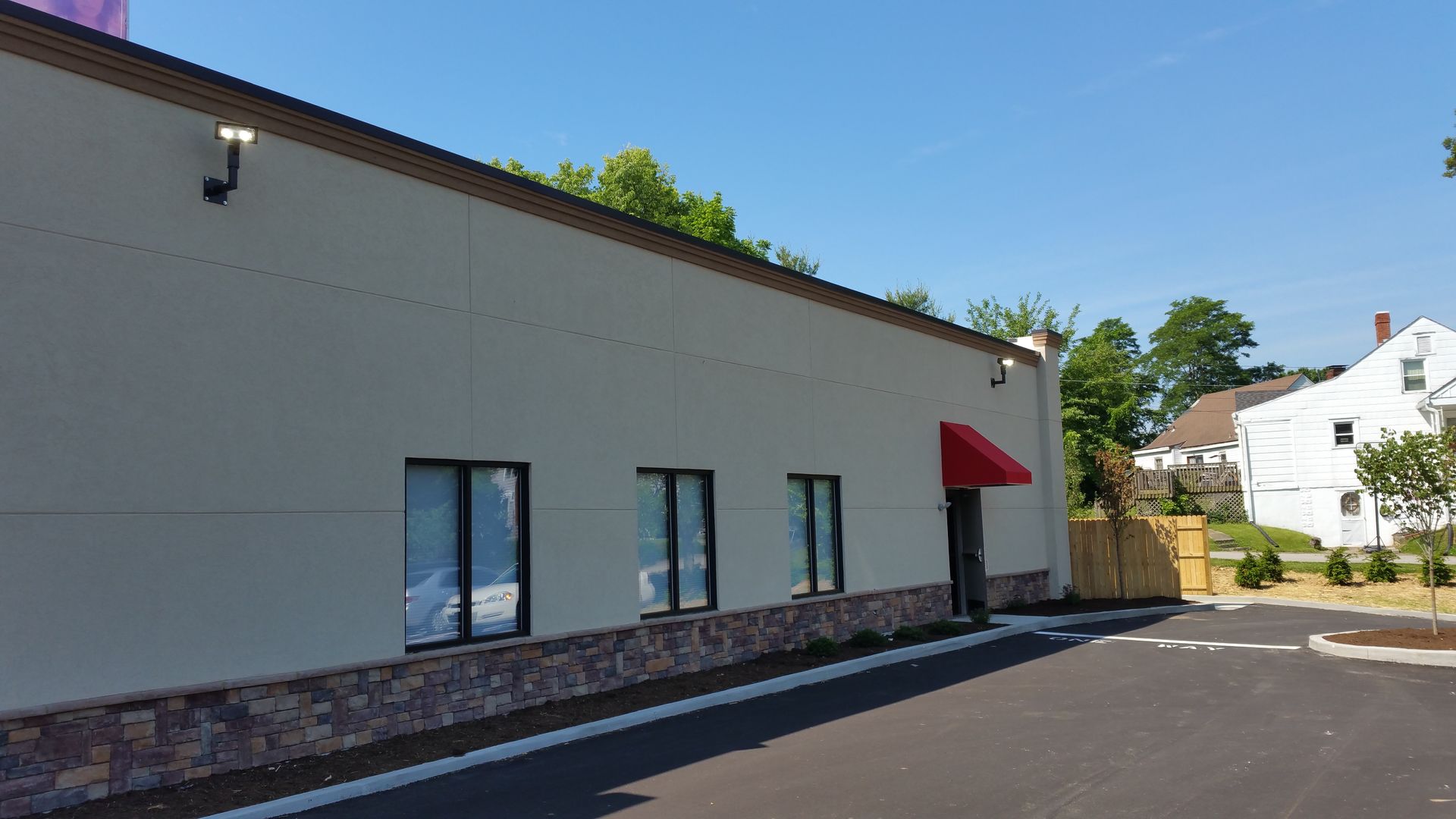 A white building with a red awning on the side of it.