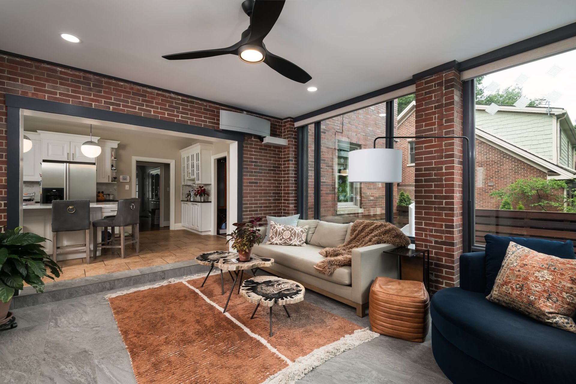 A living room with a couch , chair , rug and ceiling fan.