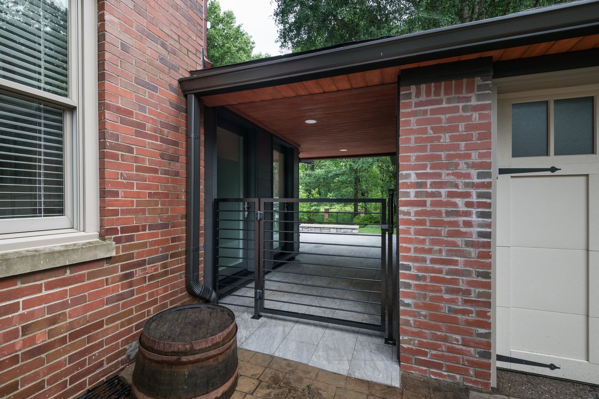 A brick building with a white door and a barrel in front of it