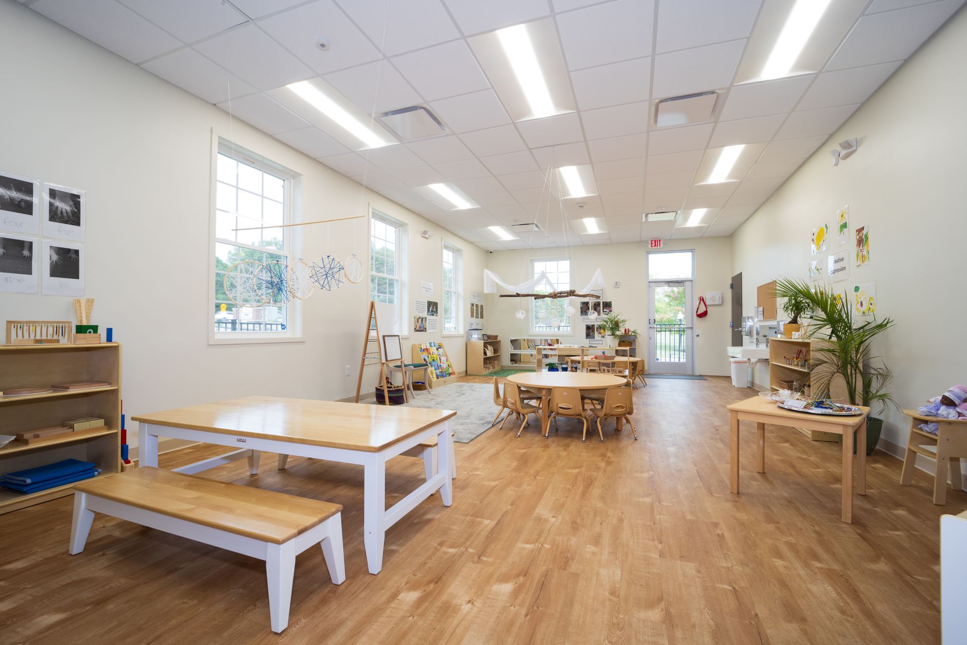 A large classroom with wooden tables and benches.