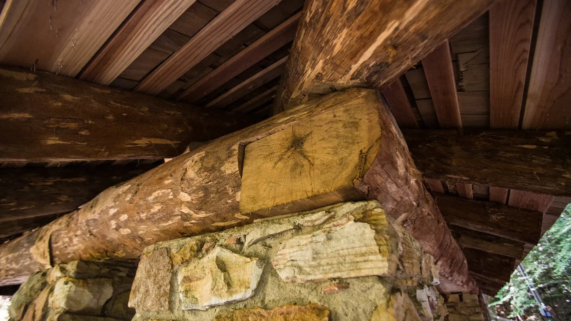 A close up of a wooden structure with a stone fireplace.
