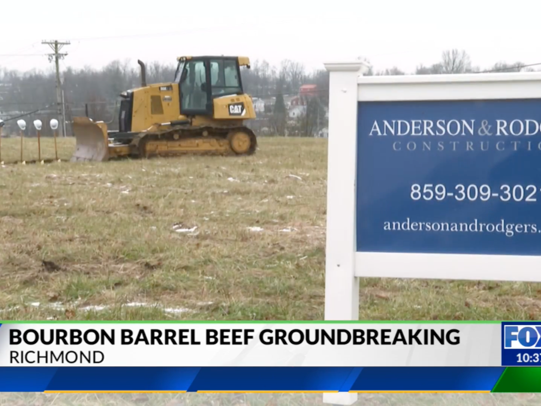 Bulldozer at Bourbon Barrel Beef groundbreaking beside Anderson & Rogers Land Surveying sign