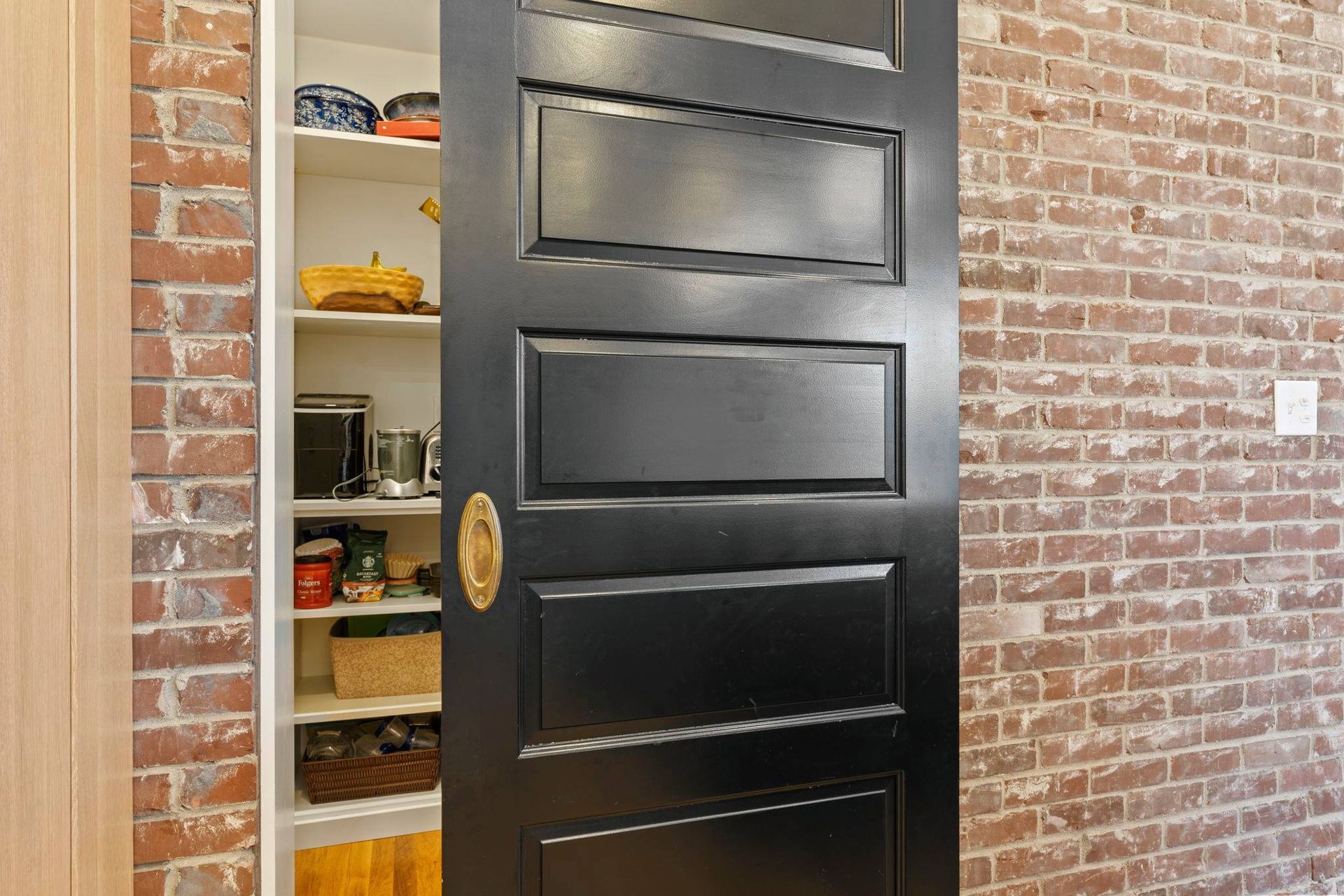 A hidden pantry within the brick walls of a historic remodel by Anderson & Rodgers Construction