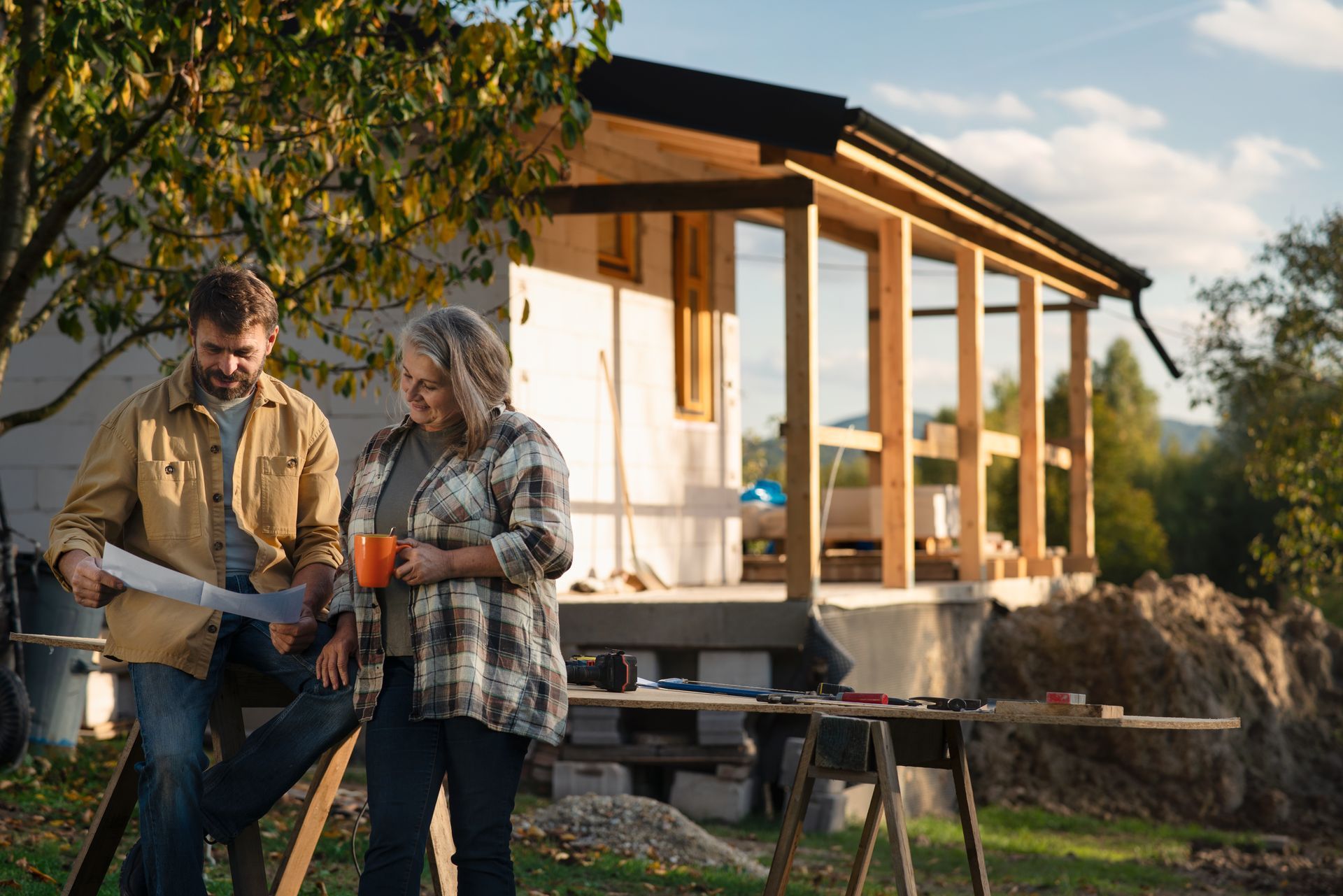 A professional exterior home remodeler chatting with a client about their home’s remodel in the back