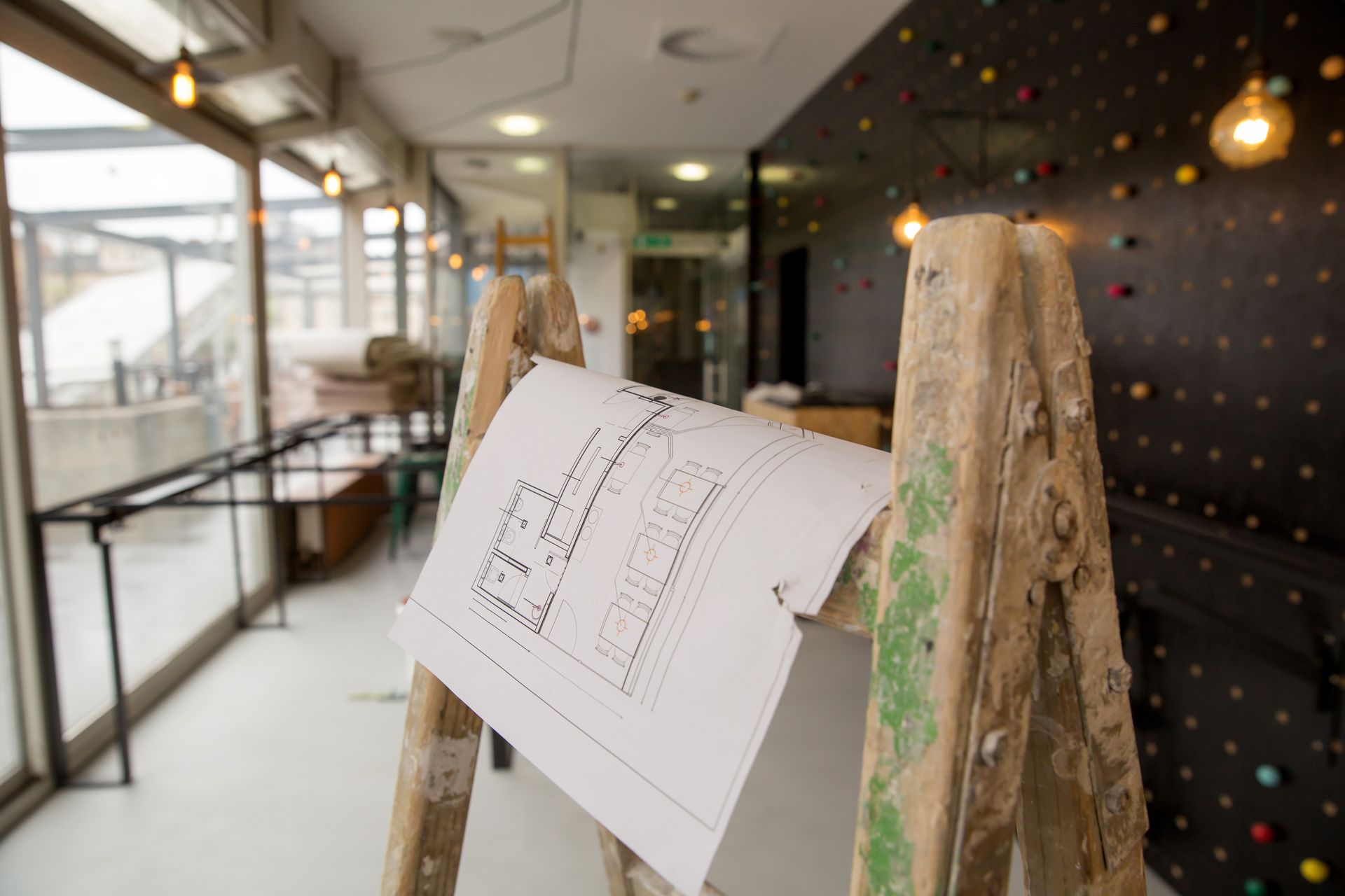 Small restaurant undergoing renovations with blueprints in the foreground.  