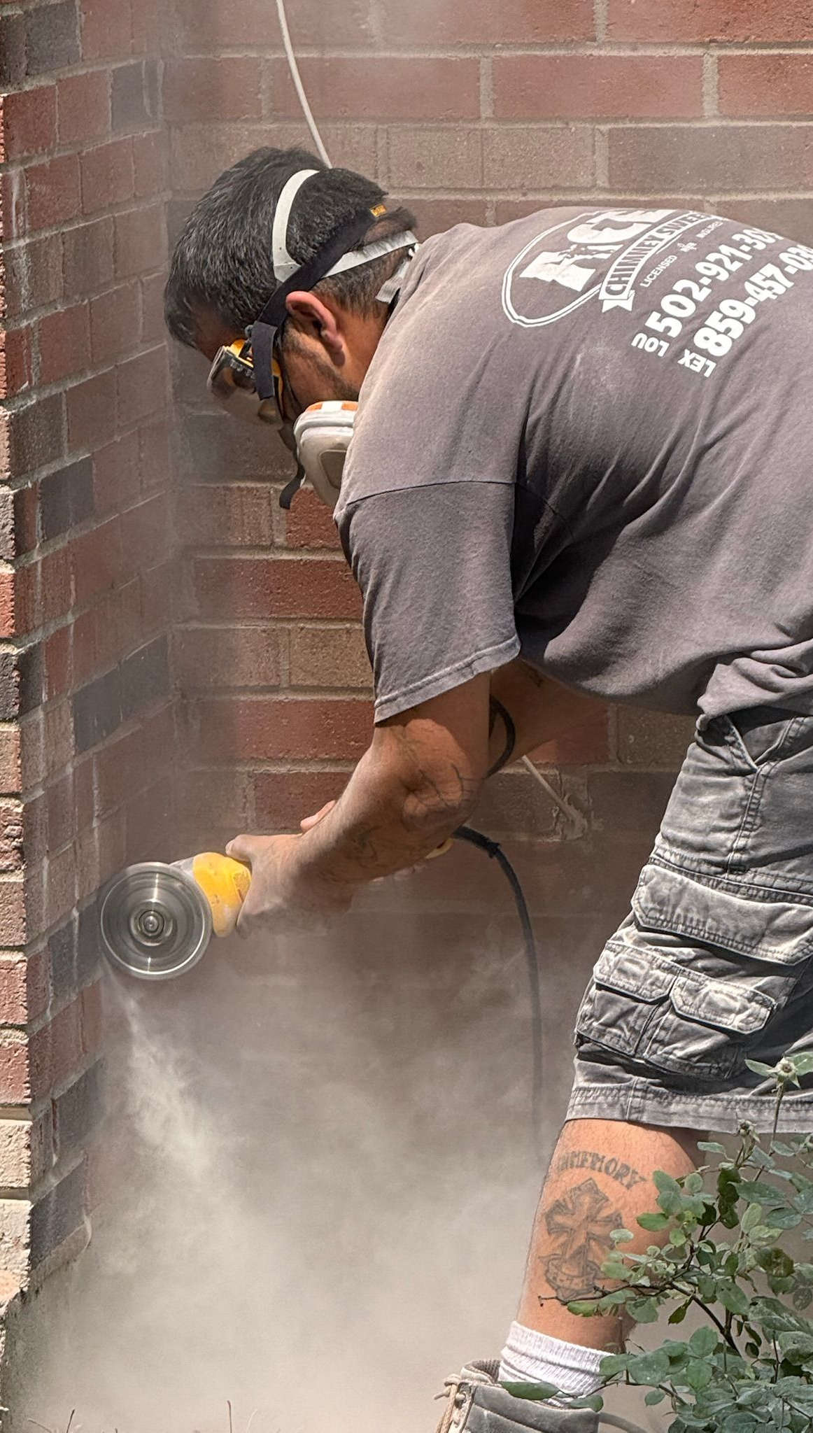 Certified chimney technician using a handheld grinder to cut brick for masonry repair