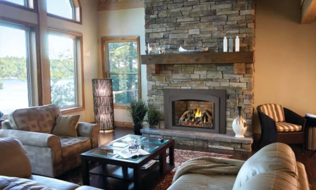 Cozy living room with stone fireplace, large windows, and beige and brown sofas around a coffee table