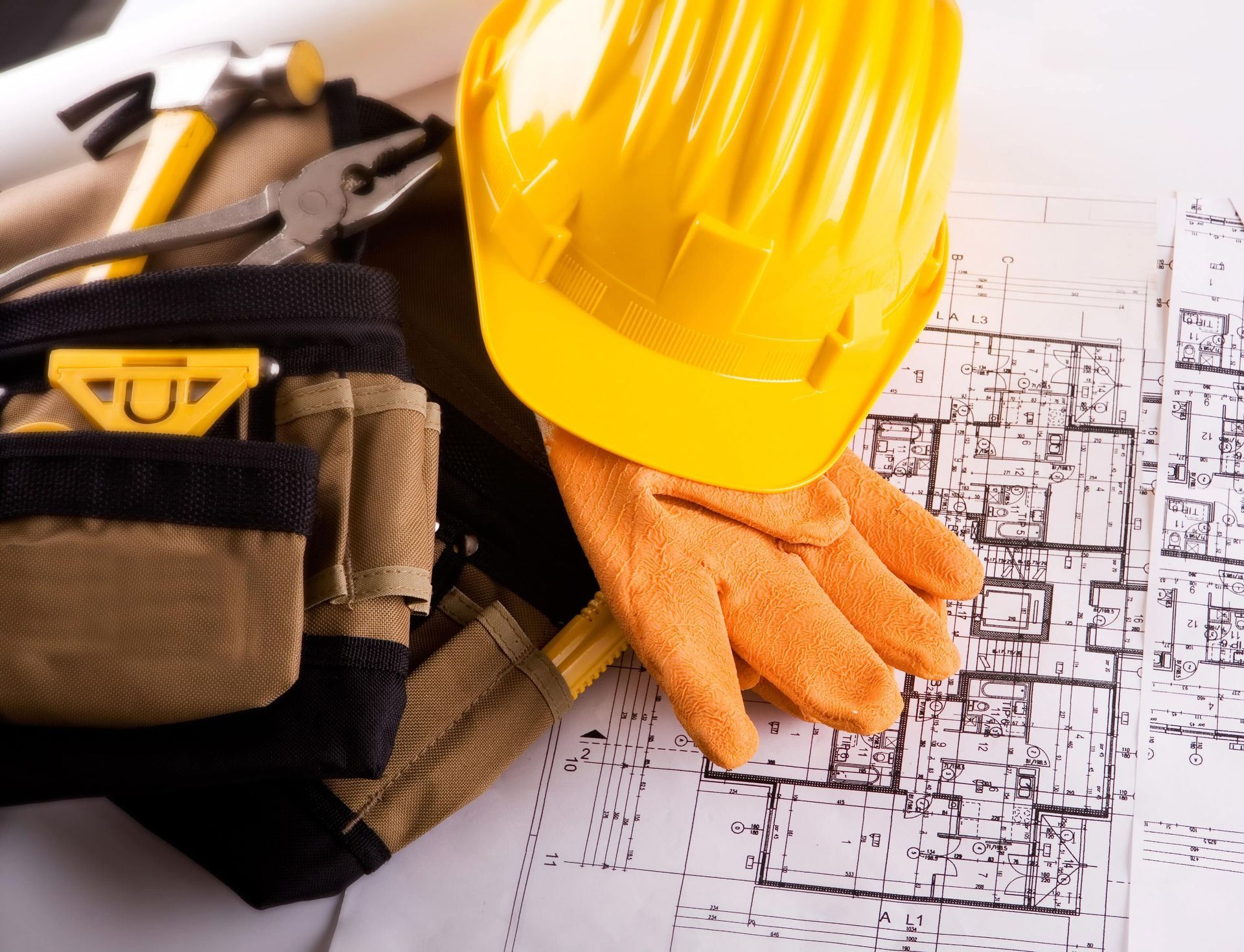A hard hat and gloves are on top of a blueprint