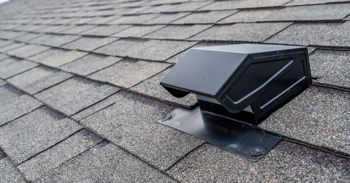 Black roof vent mounted on gray asphalt shingles, with metal flashing secured around its base for weather protection.
