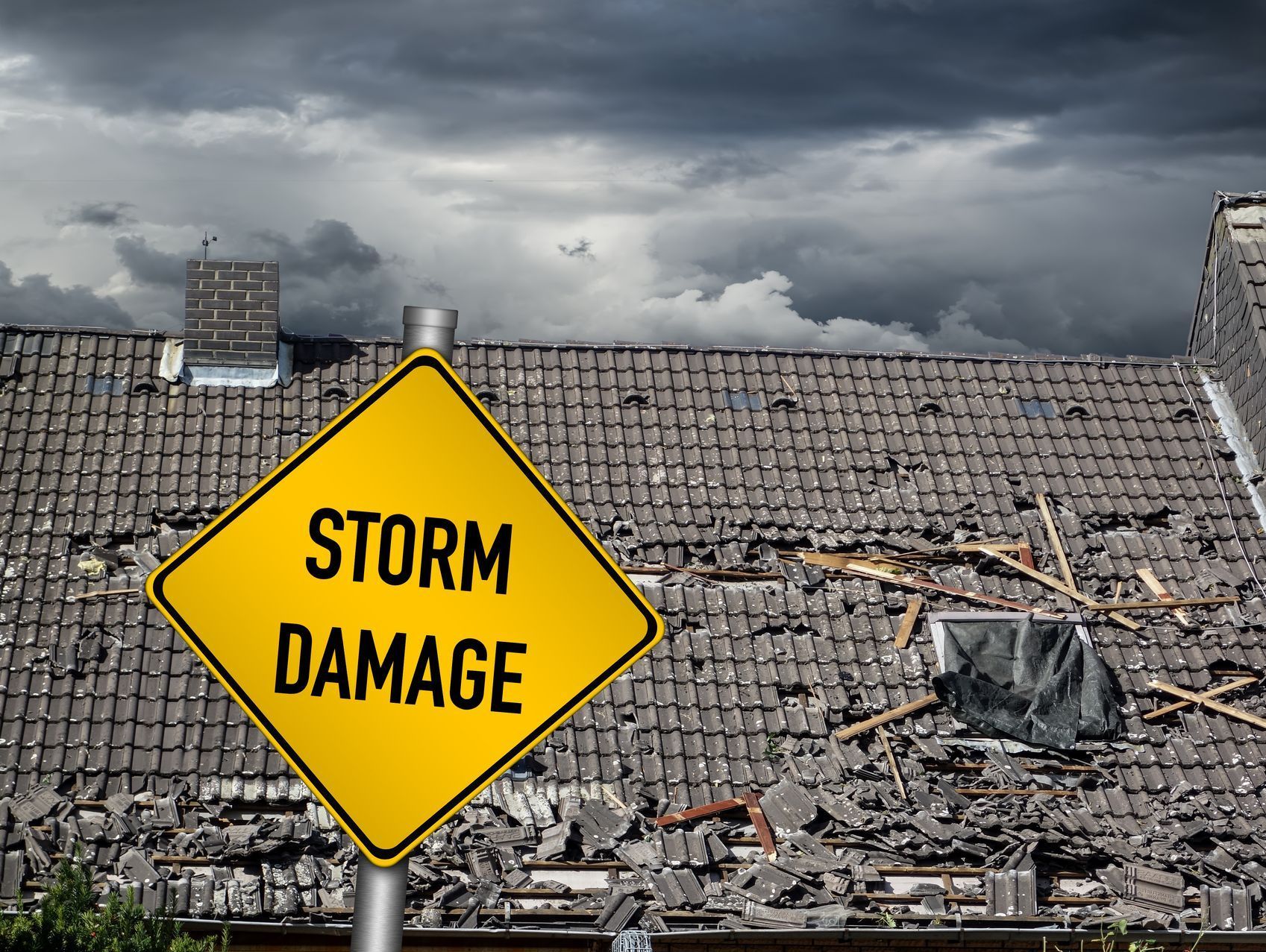 A yellow sign that says `` storm damage '' is in front of a damaged roof.