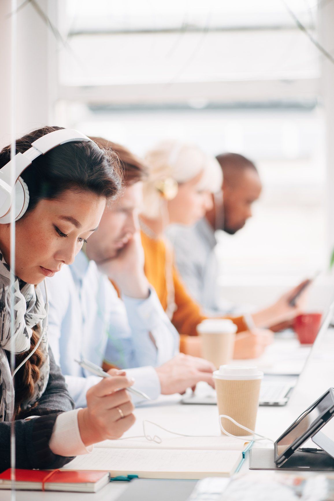 People working at Coffee Shop with Laptops and Headphones.