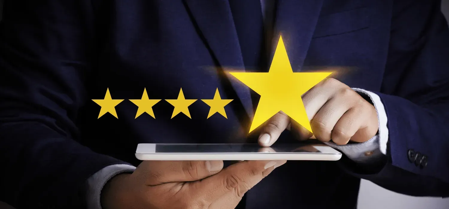Businessperson rating a tablet with five gold stars on a dark background