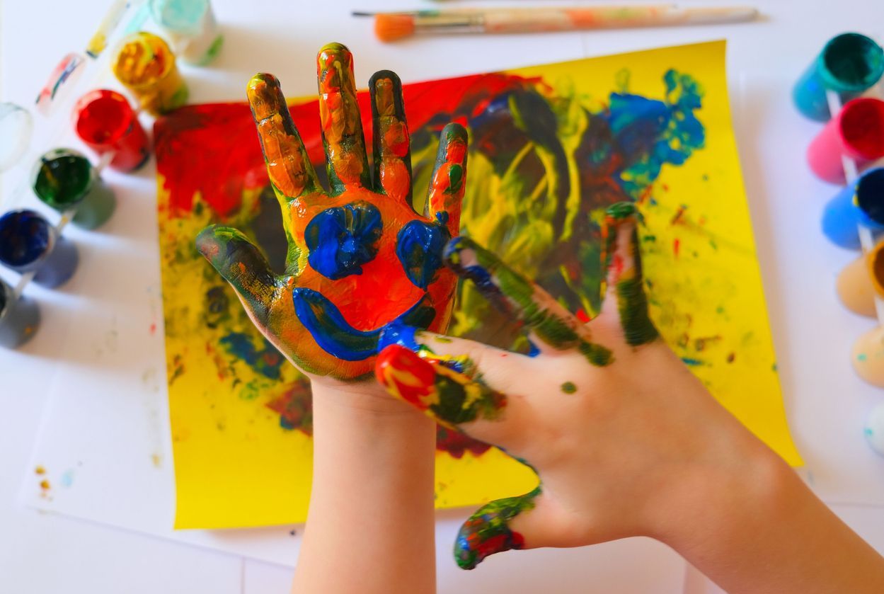 Un niño está pintando un cuadro con sus manos.