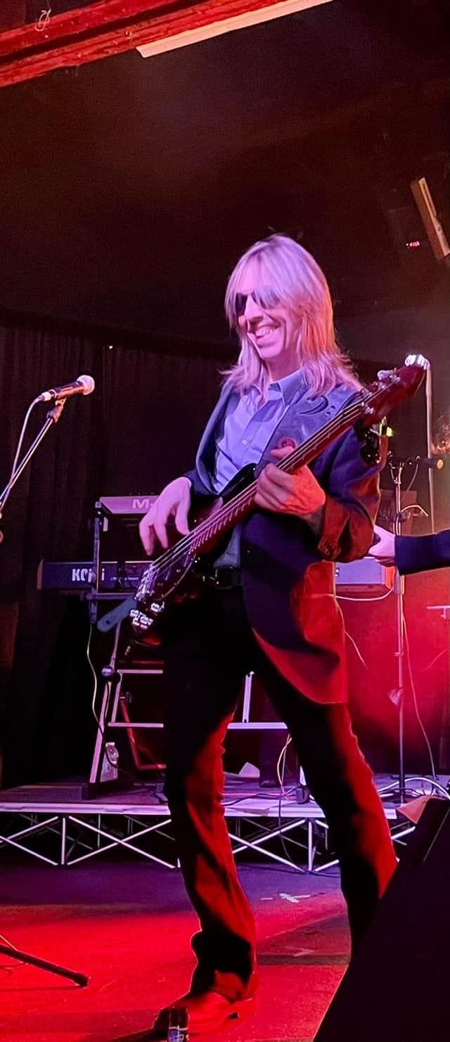 A man is playing a guitar on a stage in front of a microphone.