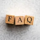 Wooden blocks spelling “FAQ” on a light textured background