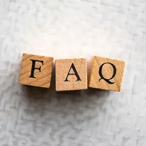 Wooden blocks spelling “FAQ” on a light textured background