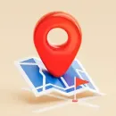 Red map pin on a folded blue map, indicating a location.