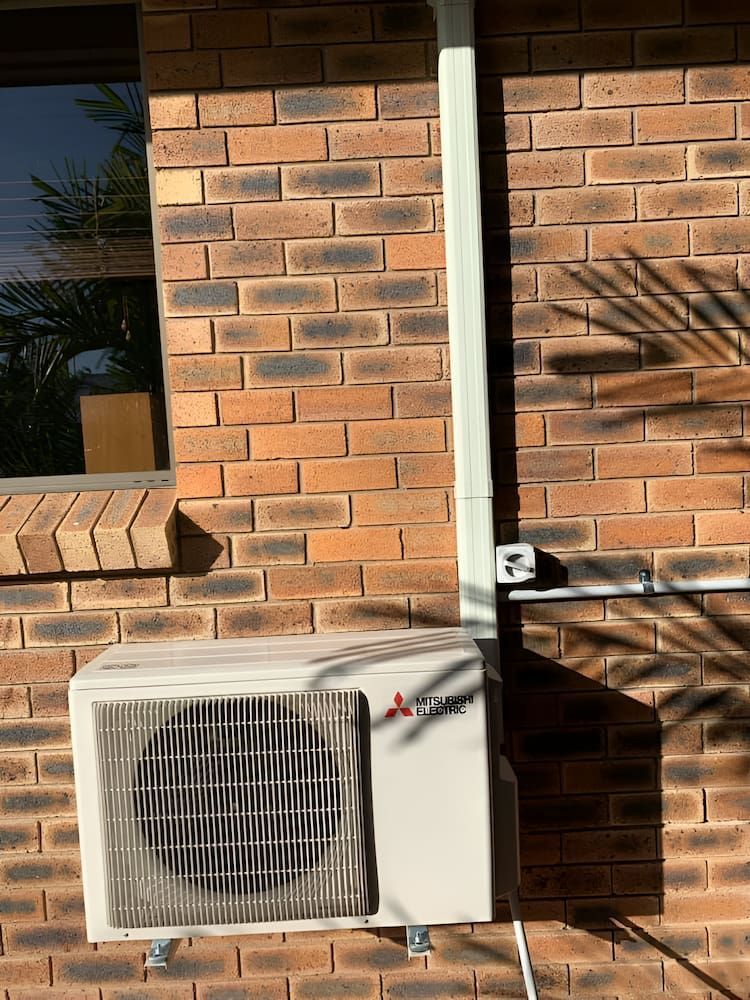 A Mitsubishi Air Conditioner Is Installed On The Side Of A Brick Building — Levi's Electrics in Nerimbera, QLD