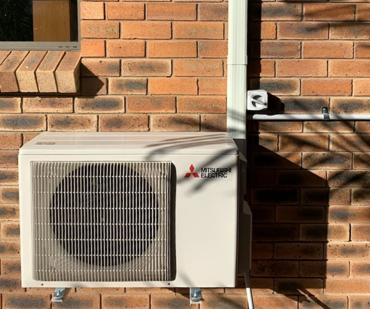 A Mitsubishi Air Conditioner Is Installed On The Side Of A Brick Building — LV Energy Solutions in Nerimbera, QLD