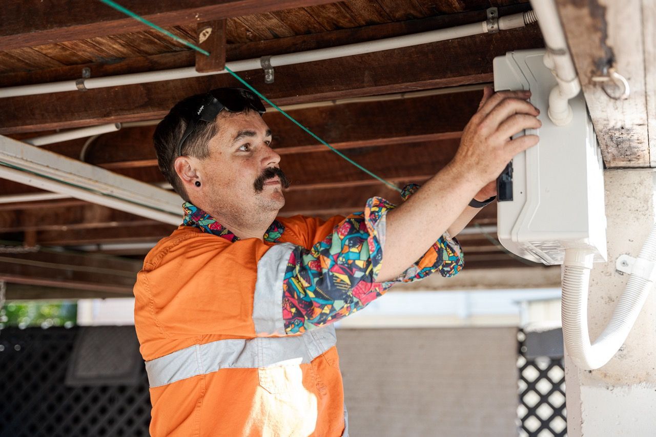 Levi Working On A Switchboard Under A House — Levi's Electrics in Nerimbera, QLD