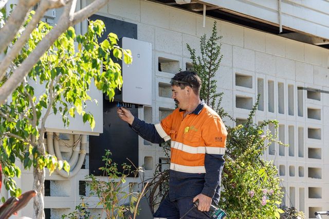 Two Men Are Standing Next To A White Truck In A Field — LV Energy Solutions in Nerimbera, QLD