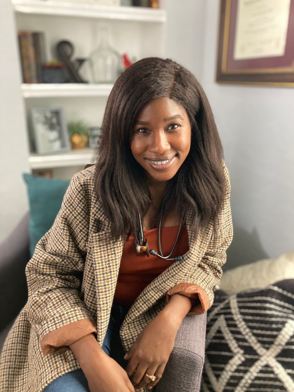 Dr. Amaka Priest sitting in armchair - pediatric concierge medicine Los Angeles