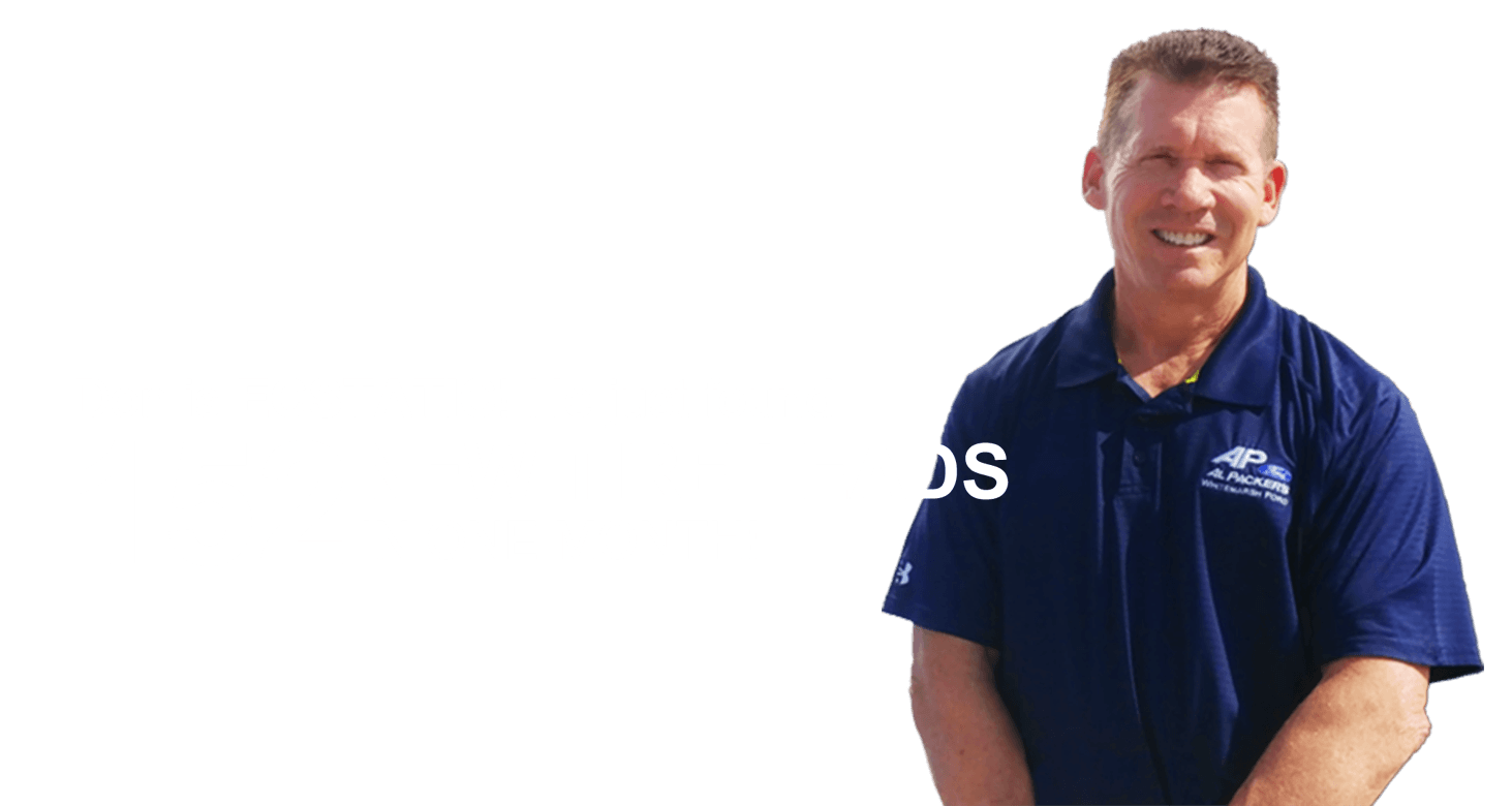 A man in a blue shirt is standing in front of a white background.