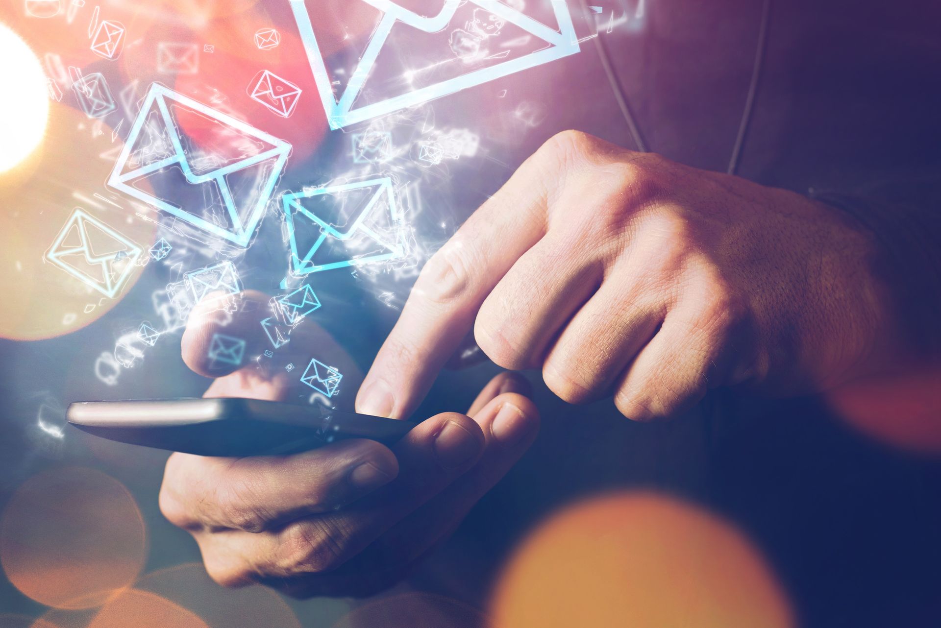 A person is using a smart phone with envelope icons coming out of it.