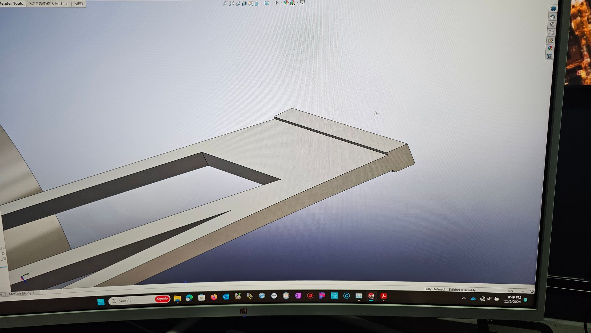 3D CAD model of a gray rectangular bracket with a cutout, shown on a computer screen