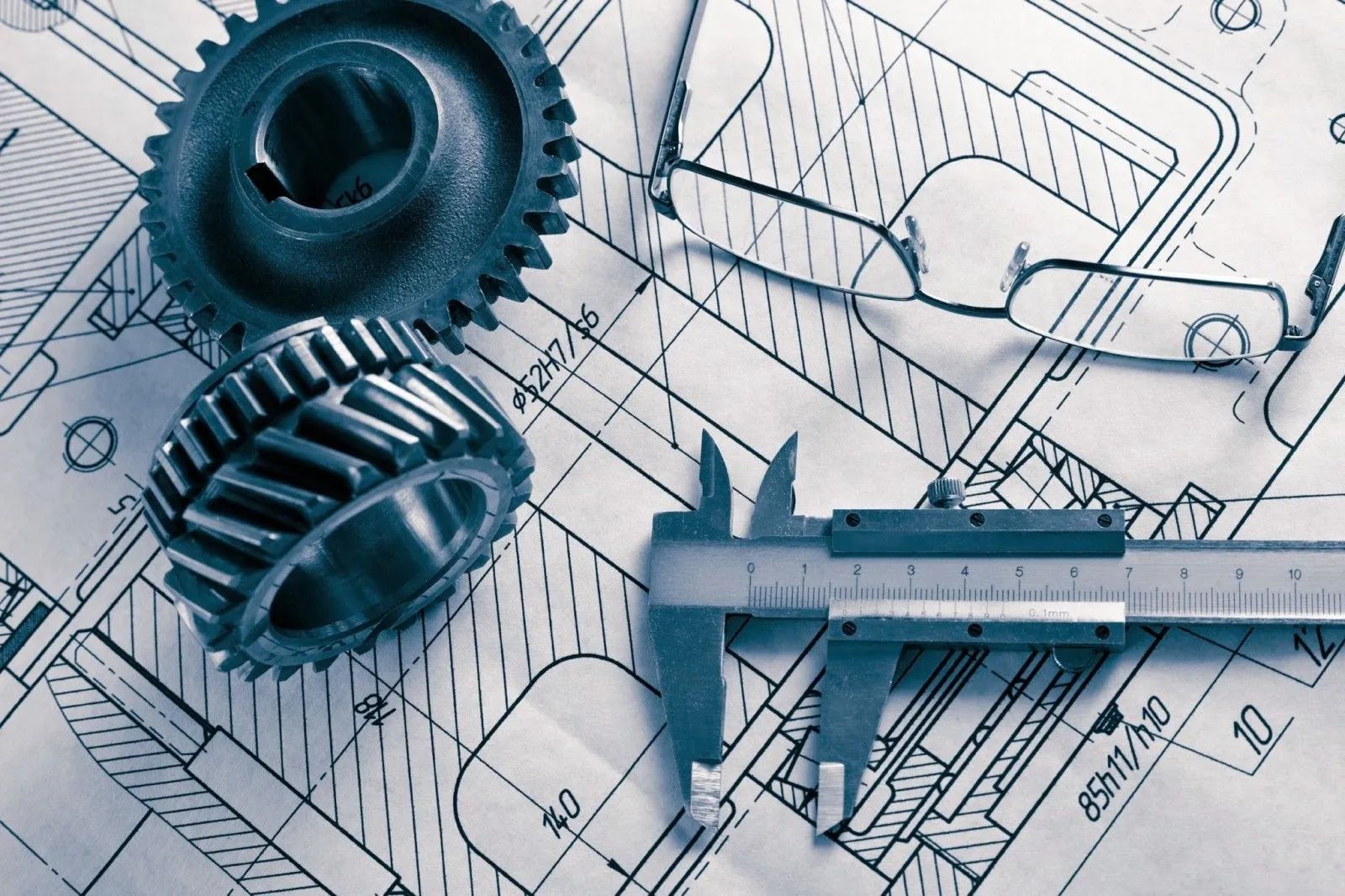 Blueprint with gears and a caliper, suggesting mechanical design or engineering planning