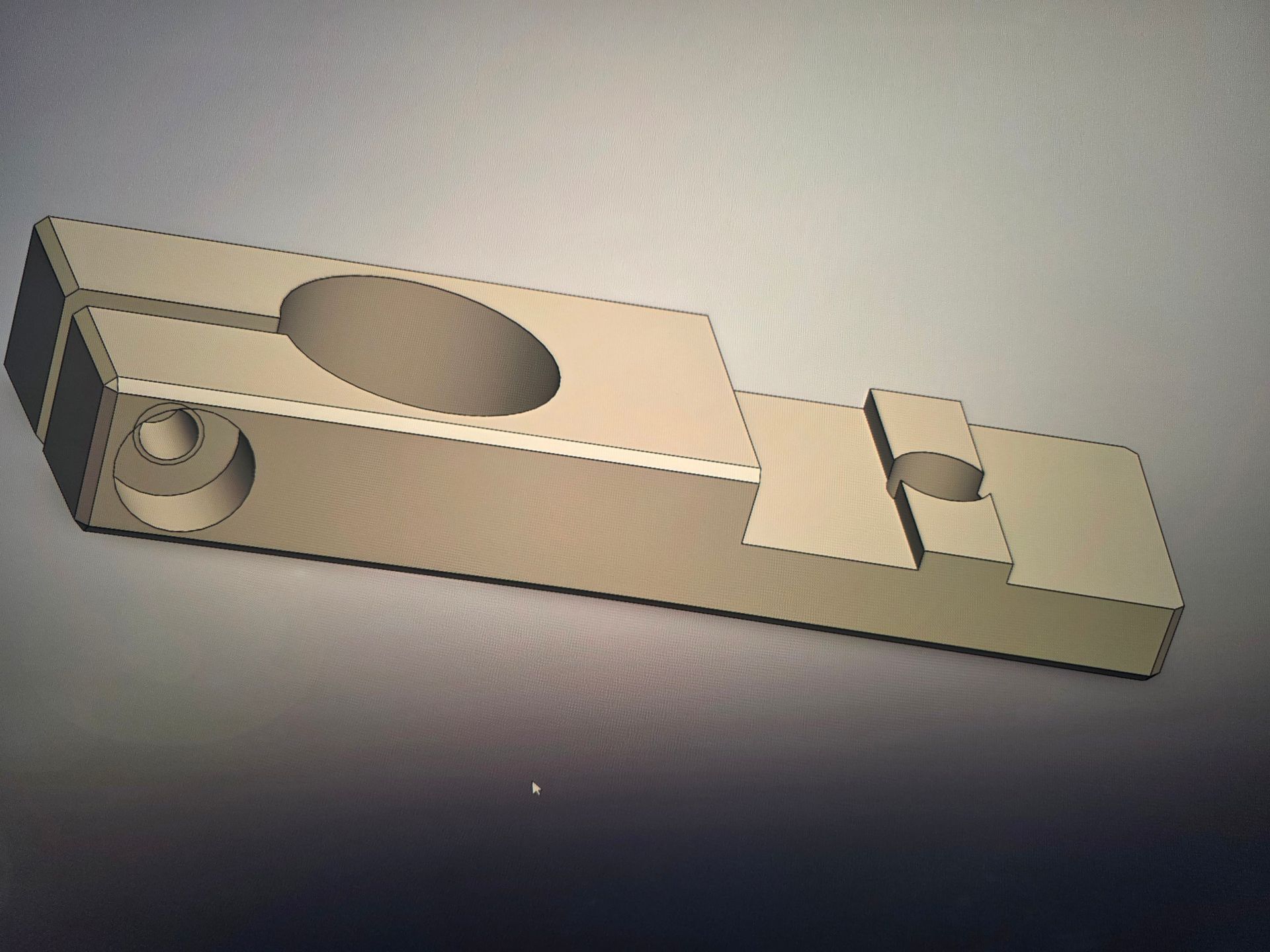 Beige mechanical metal part with a large circular hole and a side pivot hole on a gray background