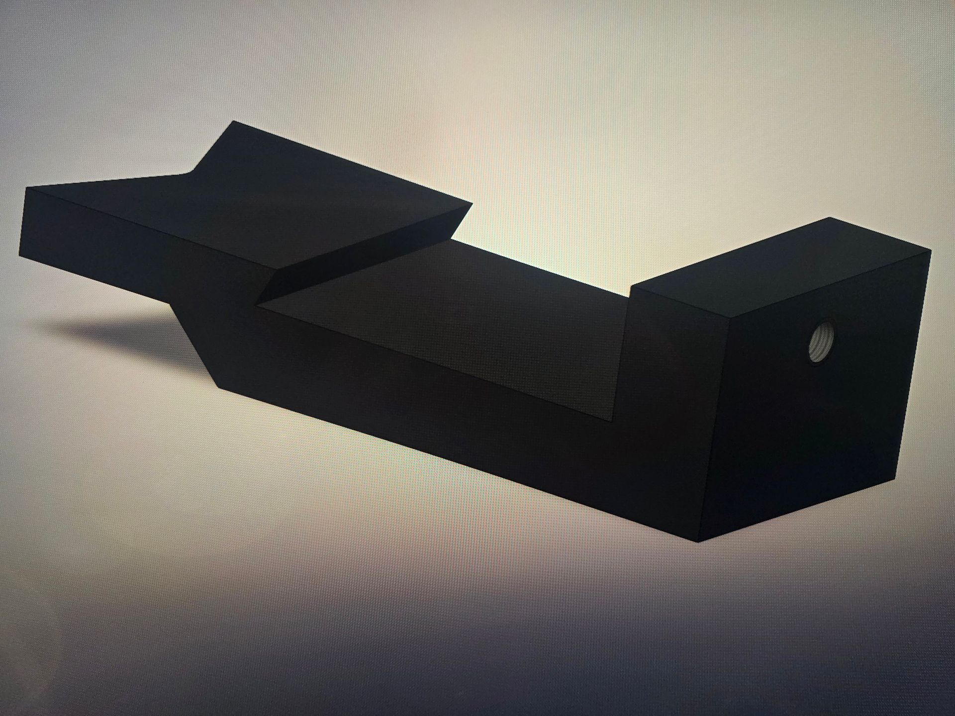 Black metal wall-mounted bracket with angled support and rectangular end block on a light background