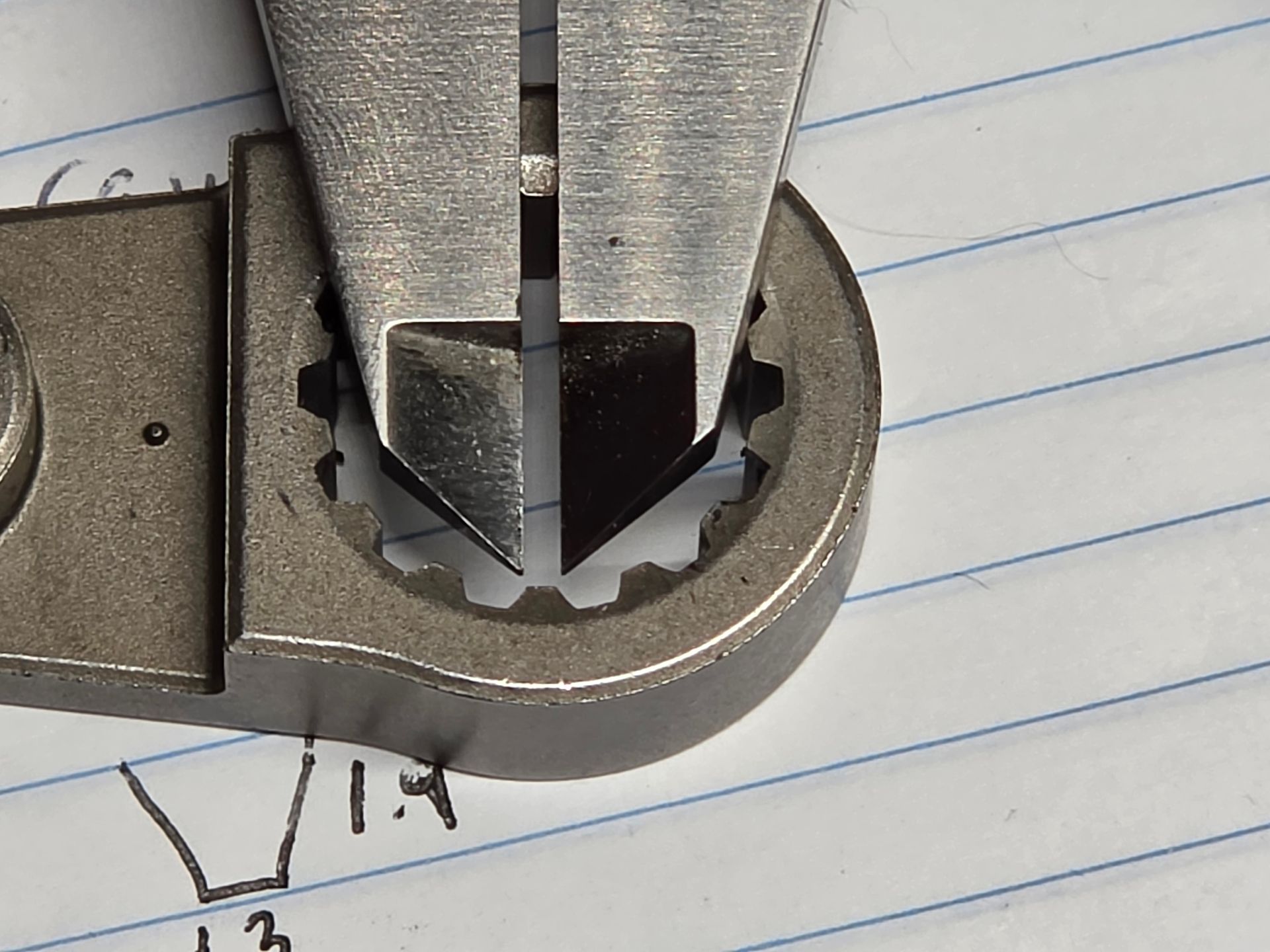 Metal tool tip pressing into a small round metal opening on lined paper