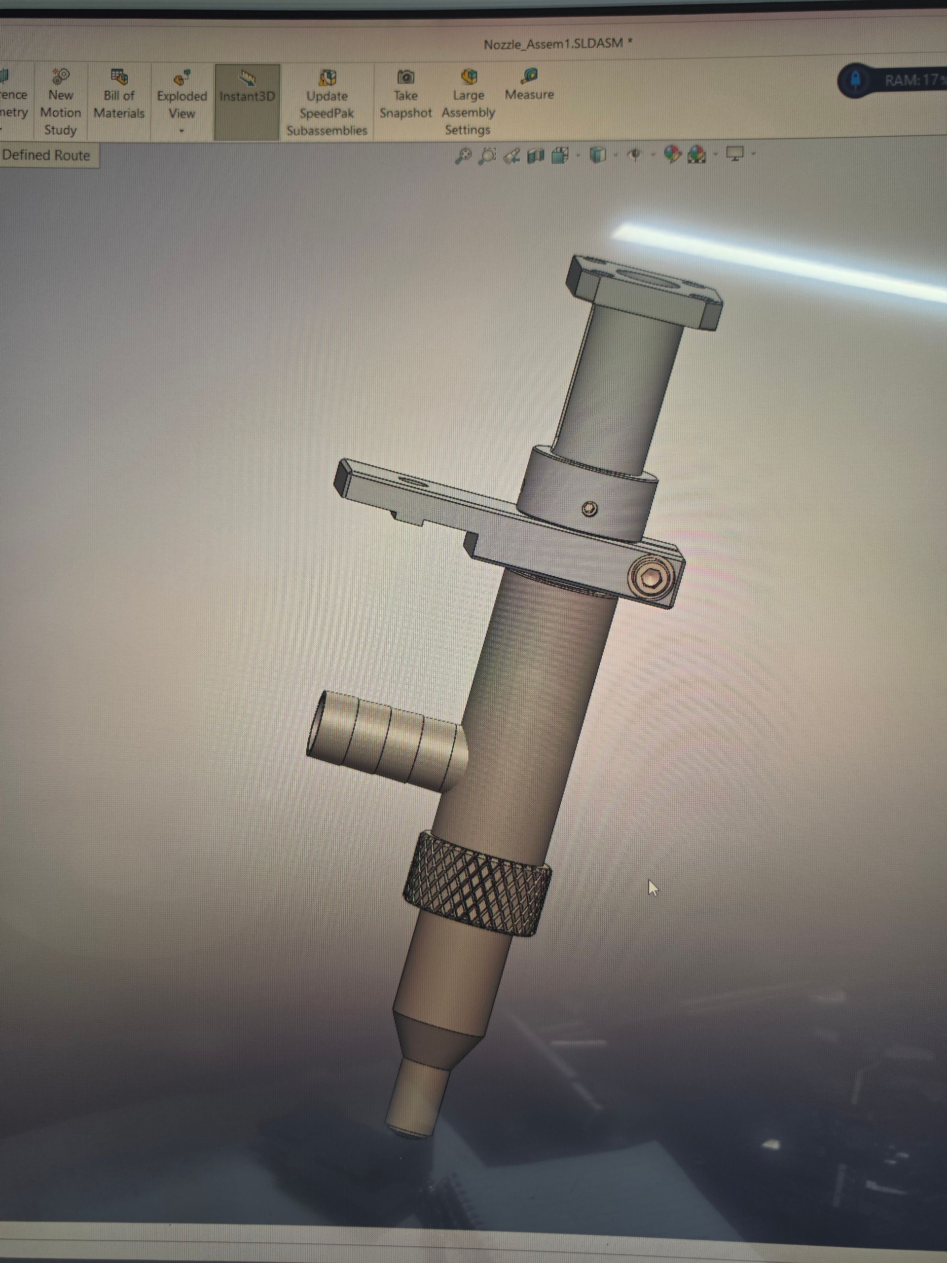 CAD model of a metallic mechanical tool with a cylindrical body and side handle, shown on a computer screen